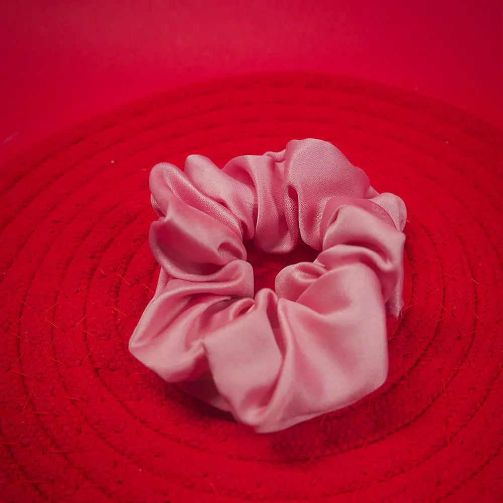 Pink scrunchie on a red textured surface