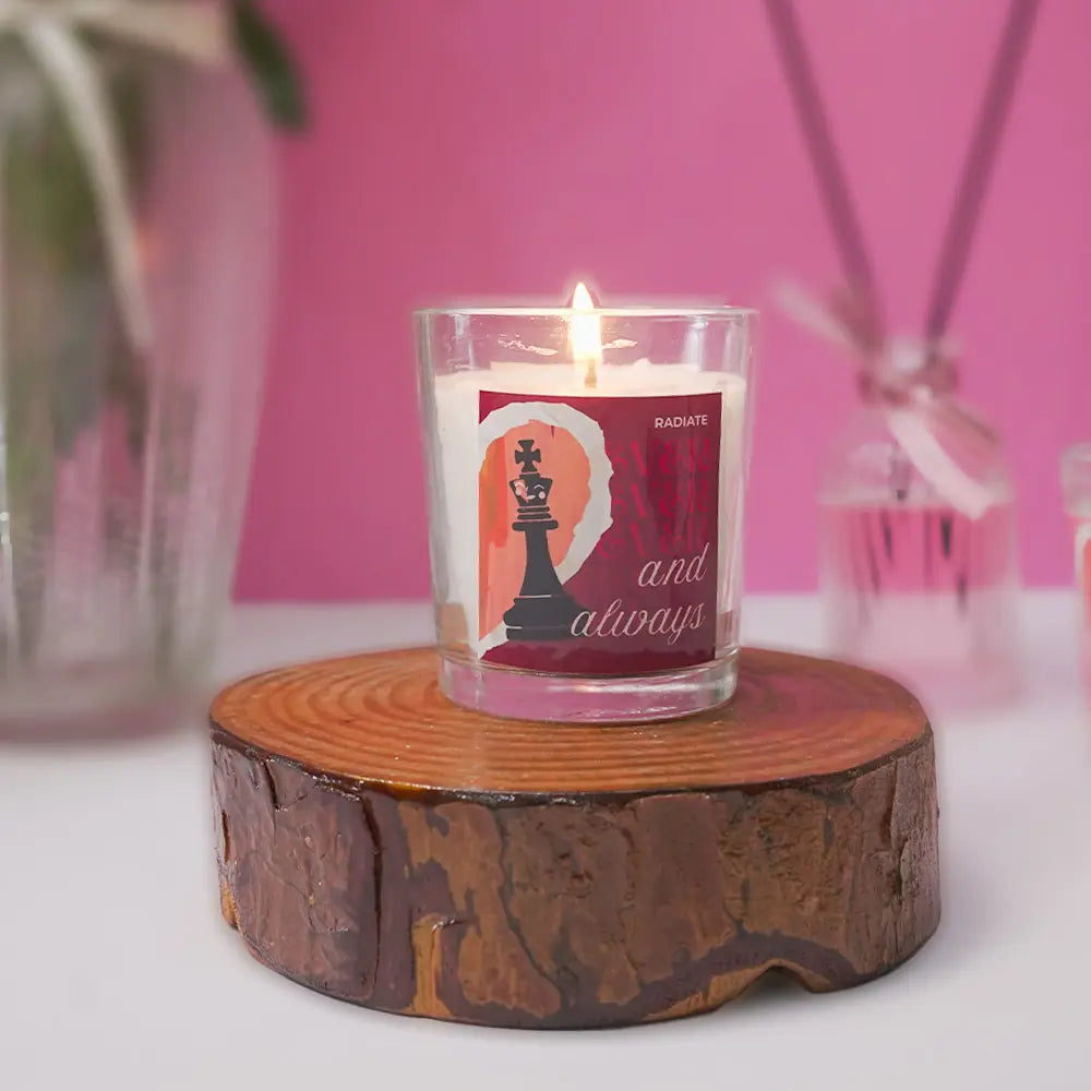 Radiate's musk scented king candle with label that says always and forever sitting on a wooden coaster against a pink background