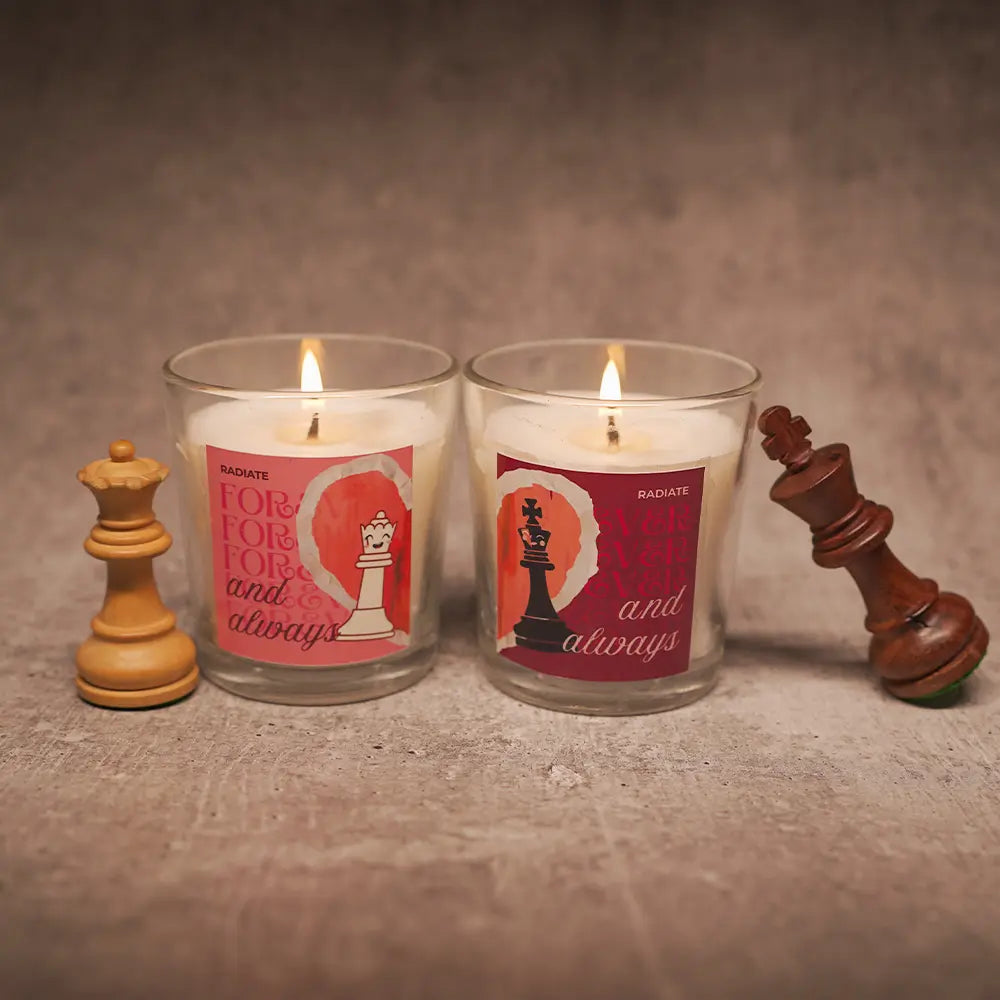 King and queen scented candle duo on a grey background with dramatic soft light and chess pieces. 