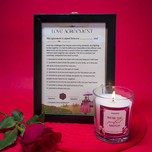 Love agreement framed with a lit Cherry blossom scented candle by Radiate with rose on a red background