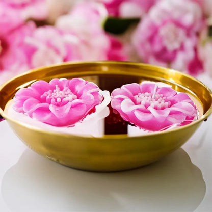 Radiate's pink lotus flower-shaped candles in a gold bowl with pink floral background