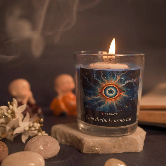 Evil eye candle by Radiate on a marble podium surrounded by pebbles and smoke. 