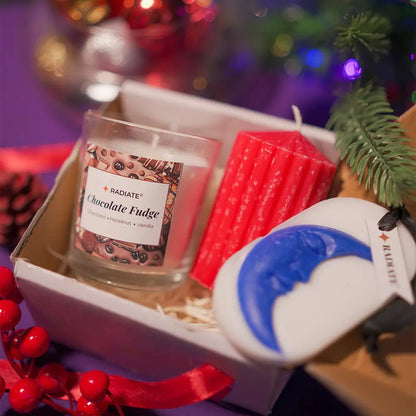 Essence trio gift combo by Radiate featuring their best-seller a chocolate fudge sweet scented candle, a beautiful red ribbed stripped pillar candle and a sweet scented wax sachet with moon shape embed for closets, drawers and closed spaces. Made for budget gifting.