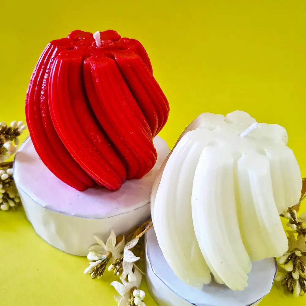 Top view of Red and white spiral swirl waves scented pillar candles on a yellow background with floral elements.