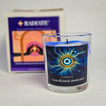 Evil eye protection scented soy wax candle with it's packaging box blurred in background.