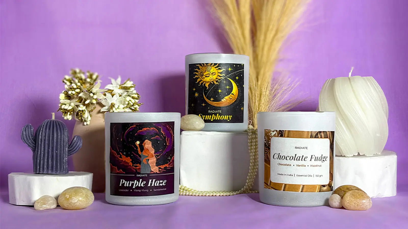 Collection of Radiate's varieties of scented candles and designer pillar candles displayed on a purple background