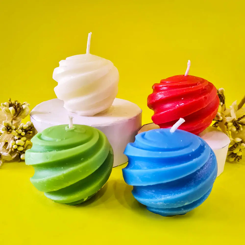 Colorful spiral swirl ball pillar candles on a yellow background